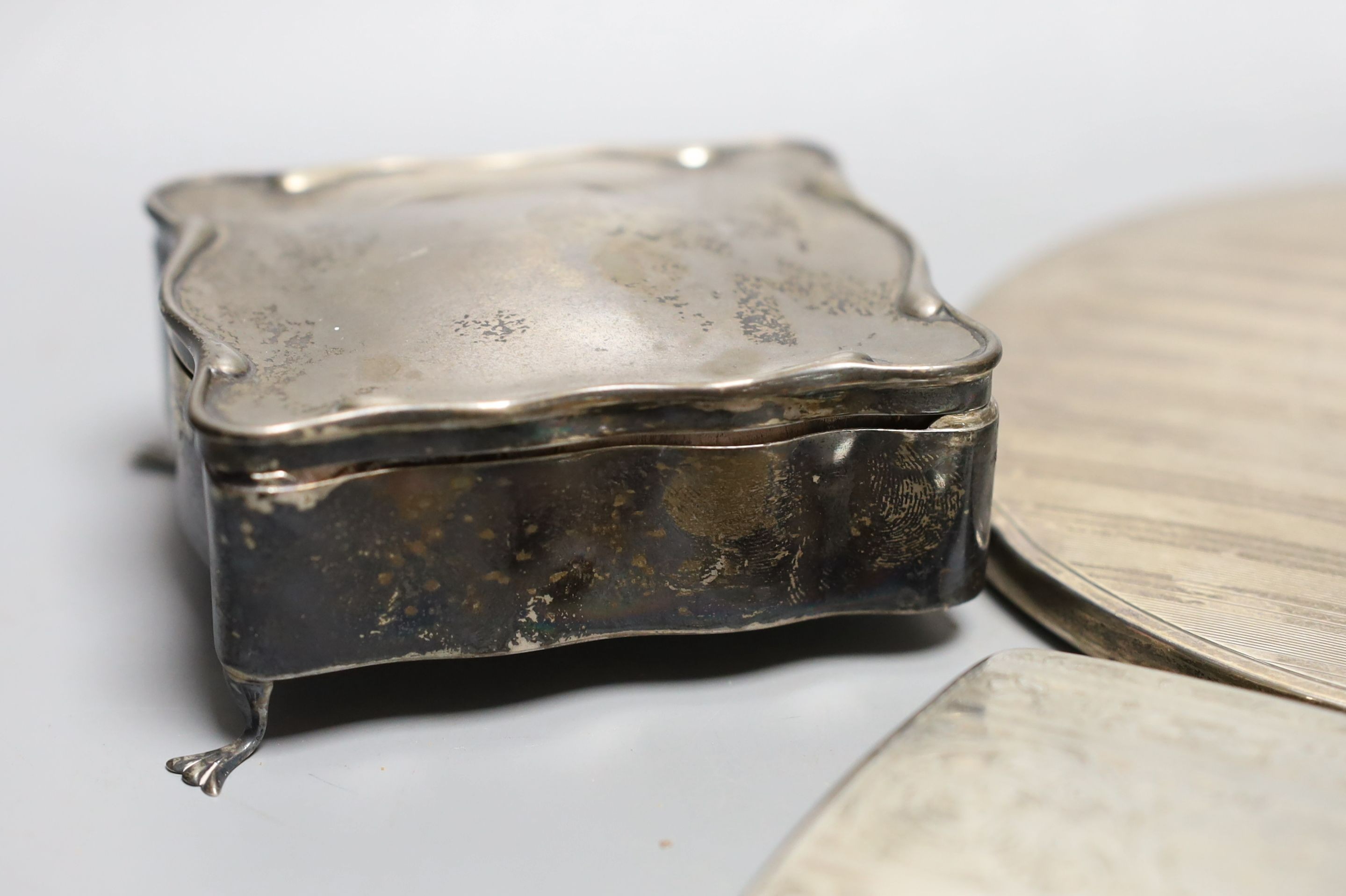 An Art Deco silver mounted cigarette box, a silver cigarette box, silver trinket box and a silver mounted hand mirror.